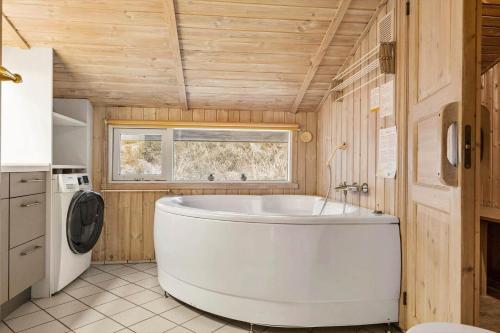 a large white tub in a bathroom with a window at 0011-Romo-Trinnesvej-9 in Bolilmark