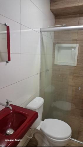a bathroom with a red sink and a toilet at Apartamento Compacto in Ananindeua