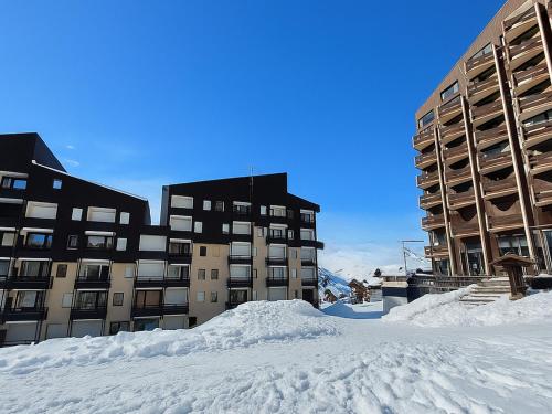 a pile of snow in front of two buildings at Studio cabine rénové, 4 pers, pied des pistes, balcon sud, près commerces et remontées. - FR-1-452-376 in Les Menuires