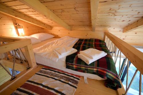 a bedroom in a wooden cabin with a bed at Montis House in Vişeu de Mijloc
