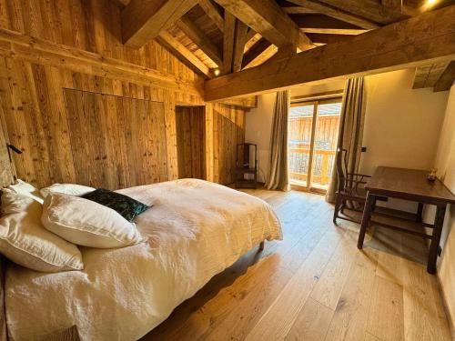 a bedroom with a bed in a room with wooden walls at Chalet de Luxe pour 12 Pers. avec Sauna et Cinéma - FR-1-452-398 in Saint-Marcel