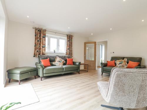 a living room with two green couches and orange pillows at Fields View in Tamworth