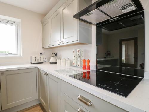 a kitchen with white cabinets and a black stove top oven at Fields View in Tamworth