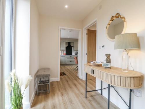 a living room with a table and a mirror at Fields View in Tamworth