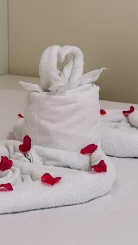 a stack of towels with red roses on a table at Village Comfort Hotel in Canindé de São Francisco