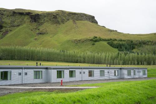 キルキュバイヤルクロイストゥルにあるAdventure Hotel Geirlandの背景に丘がある長い金属製の建物