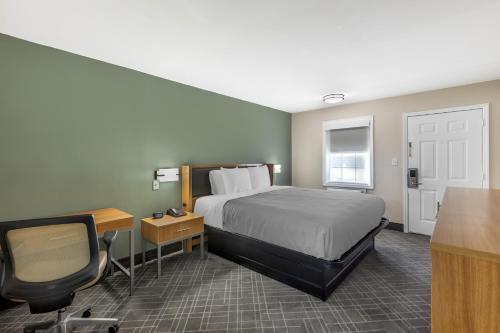a hotel room with a bed and a desk and a chair at Southern Lodge - Orangeburg 601 in Orangeburg