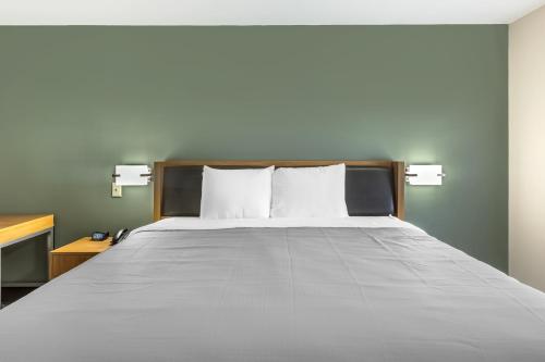 a bed with two pillows on it in a room at Southern Lodge - Orangeburg 601 in Orangeburg