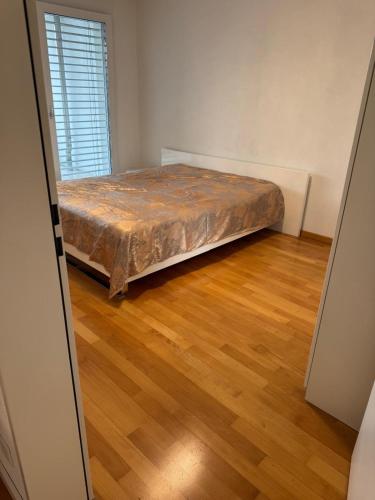 a bed in a room with a wooden floor at City Apartment in Opfikon