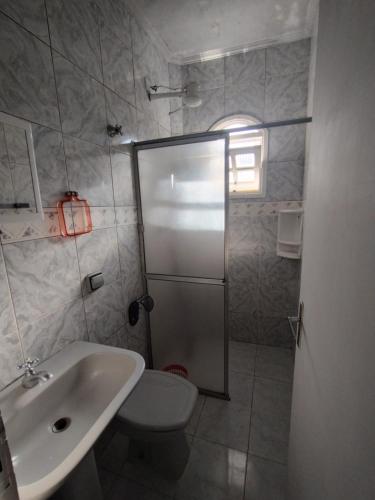 a bathroom with a shower and a sink and a toilet at Novo Encanto in Ubatuba