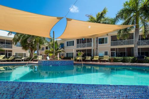 a swimming pool with an umbrella in front of a hotel at 7 Up Condo at Kaibo Kai in Driftwood Village