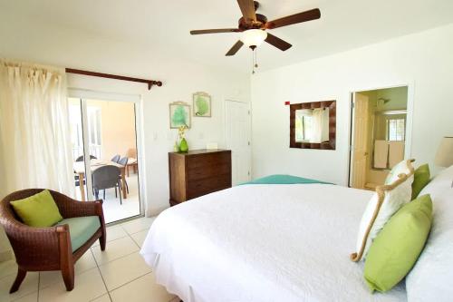 a bedroom with a white bed and a ceiling fan at 7 Up Condo at Kaibo Kai in Driftwood Village