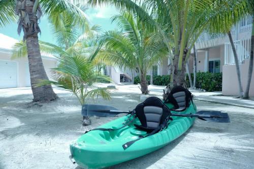 a green kayak parked on a beach with palm trees at 7 Up Condo at Kaibo Kai in Driftwood Village