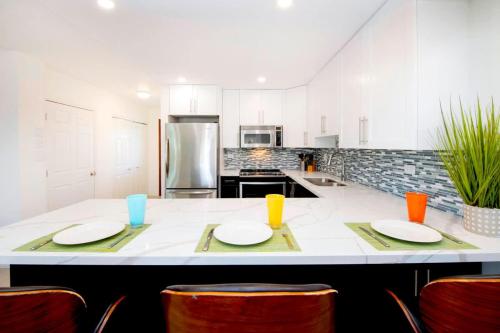 a kitchen with white cabinets and a large island with two plates at Caribbean Paradise #29 Condo in Lambert House