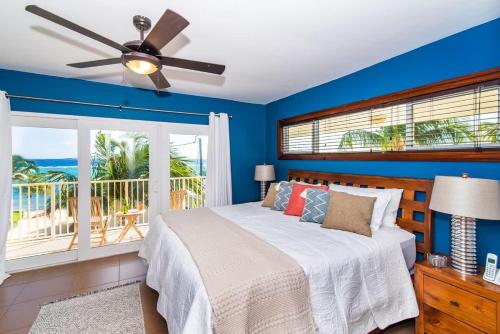 a bedroom with a bed with a ceiling fan and a balcony at Caribbean Paradise #29 Condo in Lambert House