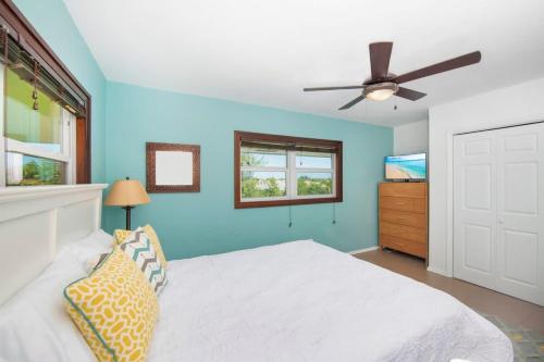 a blue bedroom with a bed and a ceiling fan at Caribbean Paradise #29 Condo in Lambert House