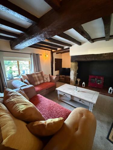 a living room with a couch and a table at Bewdley River Cottage - Free private gated parking for 2 cars - River front location in Bewdley
