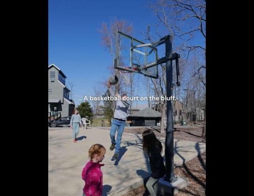 a man and a child playing basketball on a basketball court on the brink at Mr Hills Mercantile Cabin with a hot tub in Bryant