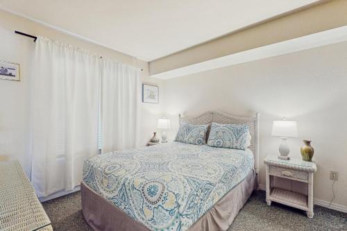 une chambre avec un lit et deux lampes et une fenêtre dans l'établissement Plantation Palms #6208, à Gulf Highlands