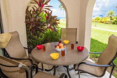 a table with a bowl of fruit on a patio at Georgetown Villas #113 in Seven Mile Beach