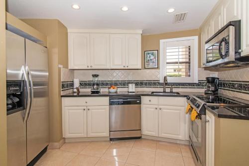 a kitchen with white cabinets and stainless steel appliances at Georgetown Villas #113 in Seven Mile Beach