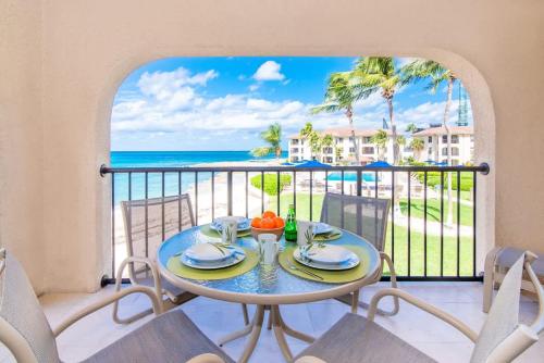 a table on a balcony with a view of the ocean at Georgetown Villas #218 in George Town