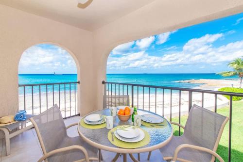 a dining room with a table and chairs and the ocean at Georgetown Villas #218 in George Town