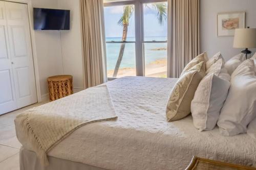 a bedroom with a bed with a view of the ocean at Georgetown Villas #218 in George Town