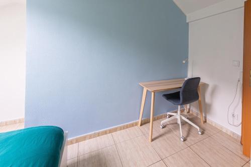 a desk and a chair in a room with a blue wall at Cosy European Instituts in Luxembourg