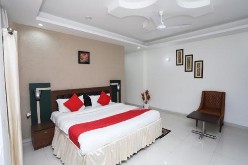 a bedroom with a large bed with red pillows at Super Capital O Levanti Near Aravali Biodiversity Park in Gurgaon