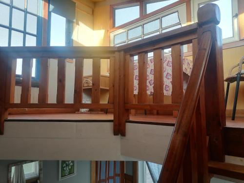 a wooden staircase in a house with a wooden railing at Habitación Refugio en la Isla in Isla Negra