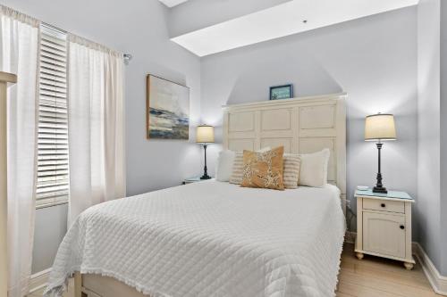 a white bedroom with a bed and two lamps at Waters Edge 606 - Oceanfront - Free Beach Service - Breathtaking Views in Fort Walton Beach