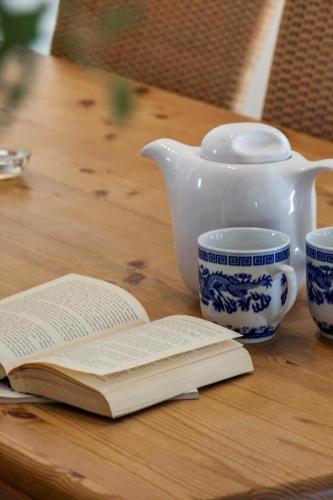 an open book on a table with a teapot and a tea pot at 2008-Romo-Froidal-10 in Toftum