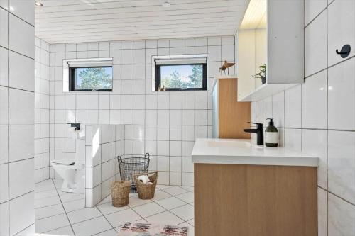 une salle de bain blanche avec un lavabo et des toilettes dans l'établissement 2701-Romo-Klitvejen-18, à Sønderby