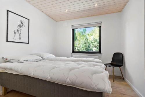 un grand lit dans une chambre avec une fenêtre dans l'établissement 2701-Romo-Klitvejen-18, à Sønderby
