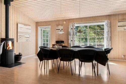 a dining room with a black table and chairs at 2608-Romo-Sonderstrandvej-18 in Mølby