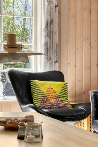 a black leather chair with a colorful pillow on it at 2608-Romo-Sonderstrandvej-18 in Mølby