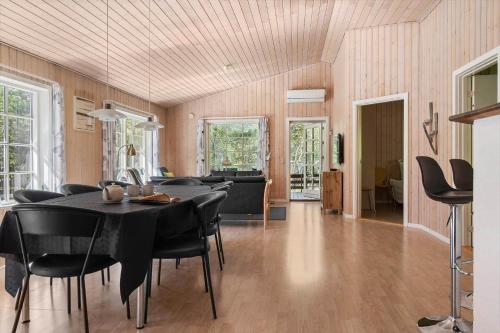 a dining room with a black table and black chairs at 2608-Romo-Sonderstrandvej-18 in Mølby