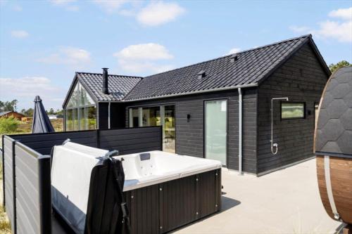 a black house with a white bath tub on a roof at 2551-Romo-Chresten-Krommes-vej-5 in Tagholm