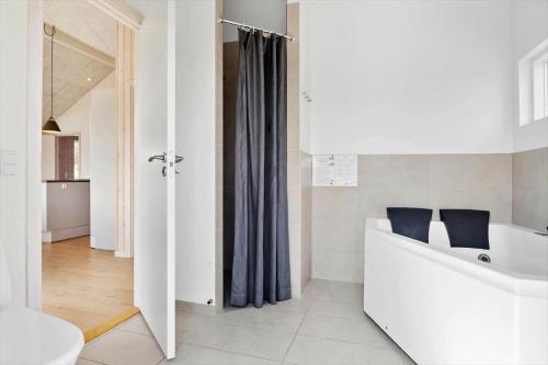 a white bathroom with a tub and a sink at 2551-Romo-Chresten-Krommes-vej-5 in Tagholm