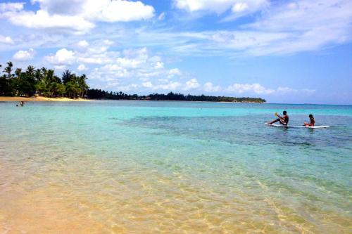 two people on surfboards in the water on a beach at 2BR, Private Pool, Modern, Close to Beach in Las Terrenas