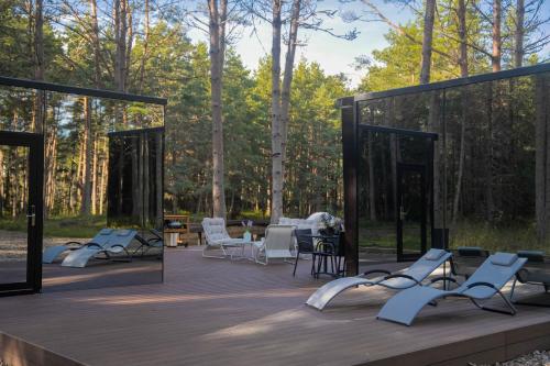 a wooden deck with chairs and tables and trees at Tiny holiday complex in Kalana in Kalana