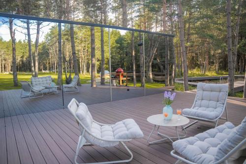 a wooden deck with chairs and a table on a patio at Tiny holiday complex in Kalana in Kalana