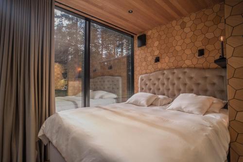 a bedroom with a large bed and a large window at Tiny holiday complex in Kalana in Kalana
