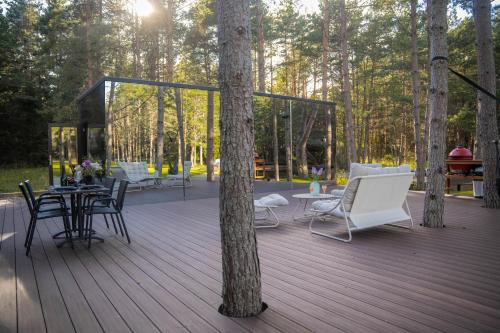 a wooden deck with chairs and tables in a forest at Tiny holiday complex in Kalana in Kalana