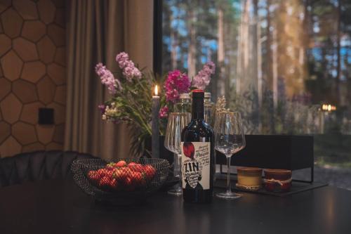 a bottle of wine and a bowl of fruit on a table at Tiny holiday complex in Kalana in Kalana