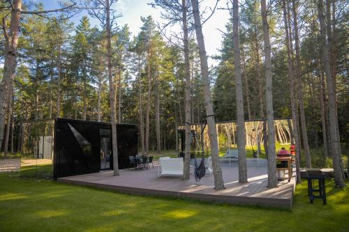 a glass house in the woods with a deck at Tiny holiday complex in Kalana in Kalana