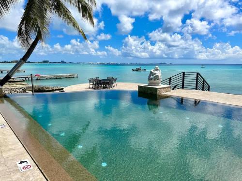 a swimming pool with a view of the ocean at Seven Mile View Condo #4 in West Bay