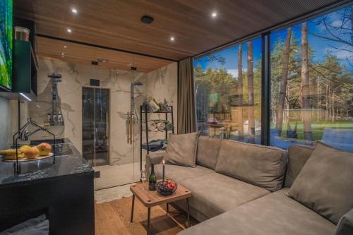 a living room with a couch and a large window at Tiny holiday complex in Kalana in Kalana