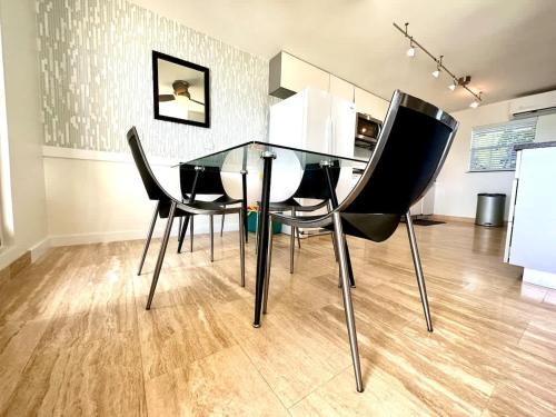 a dining room with a glass table and black chairs at Seven Mile View Condo #4 in West Bay